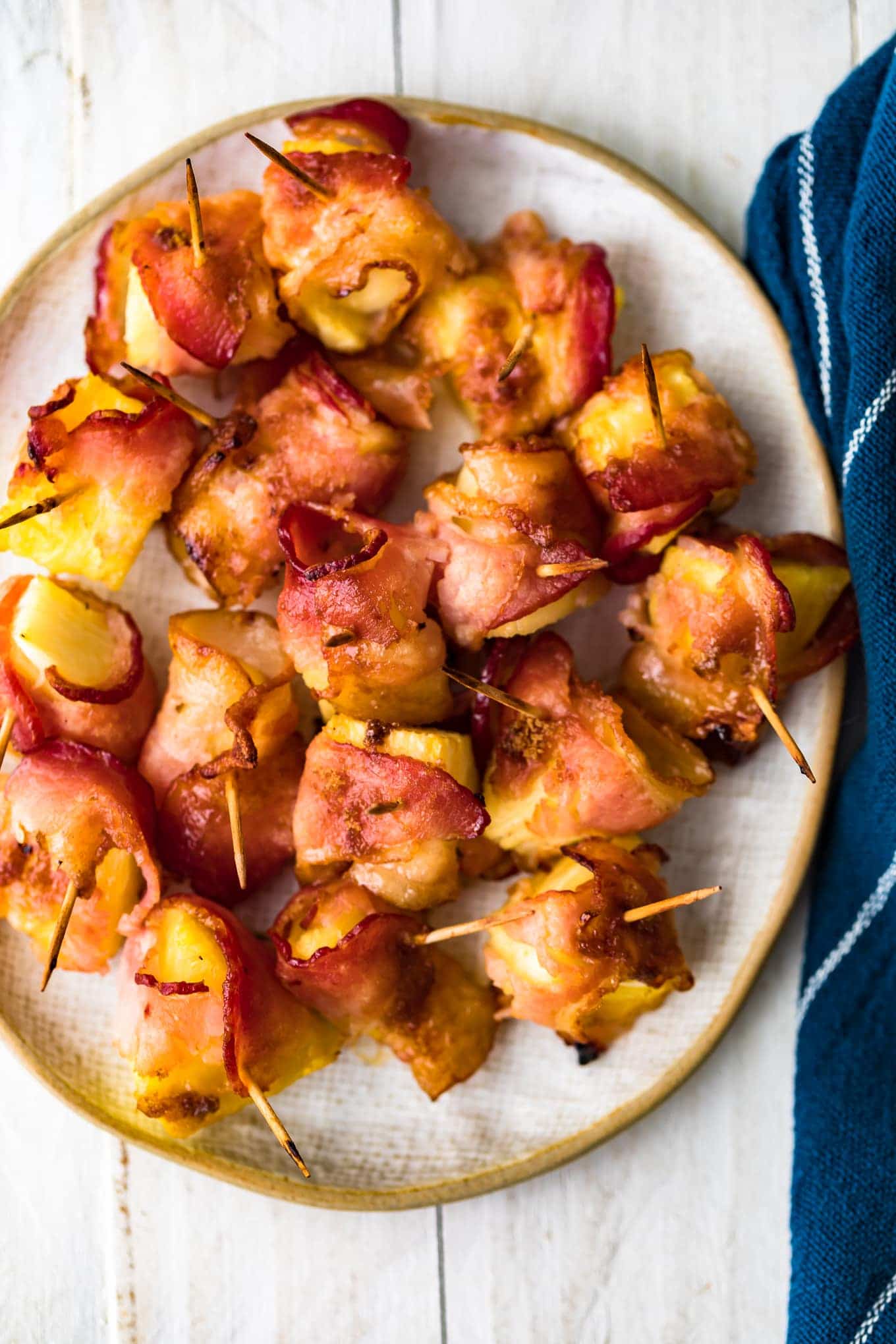 Top down shot of bacon wrapped pineapple on a serving plate