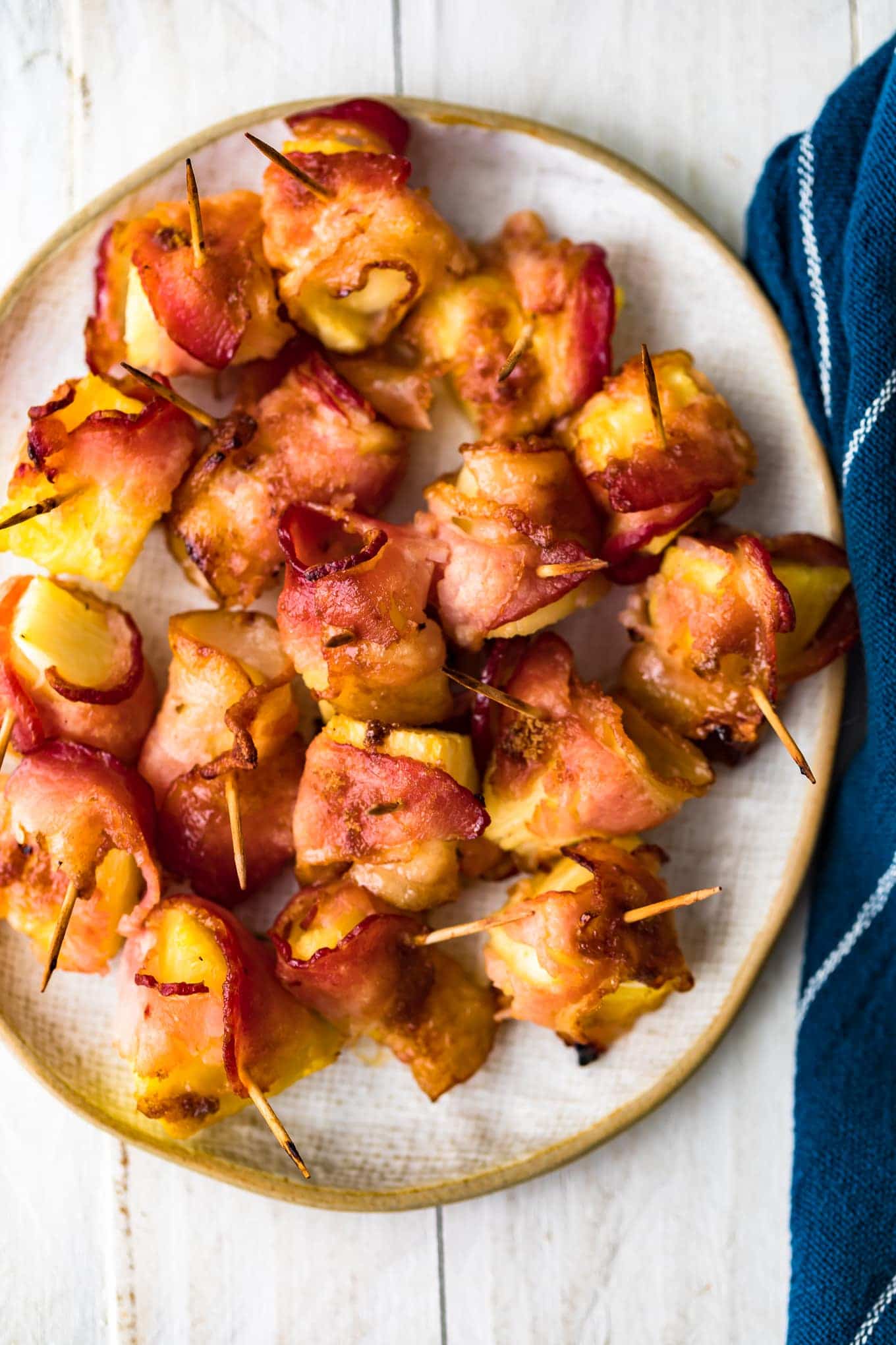 Plan haut vers le bas d'ananas enveloppé de bacon sur une assiette de service