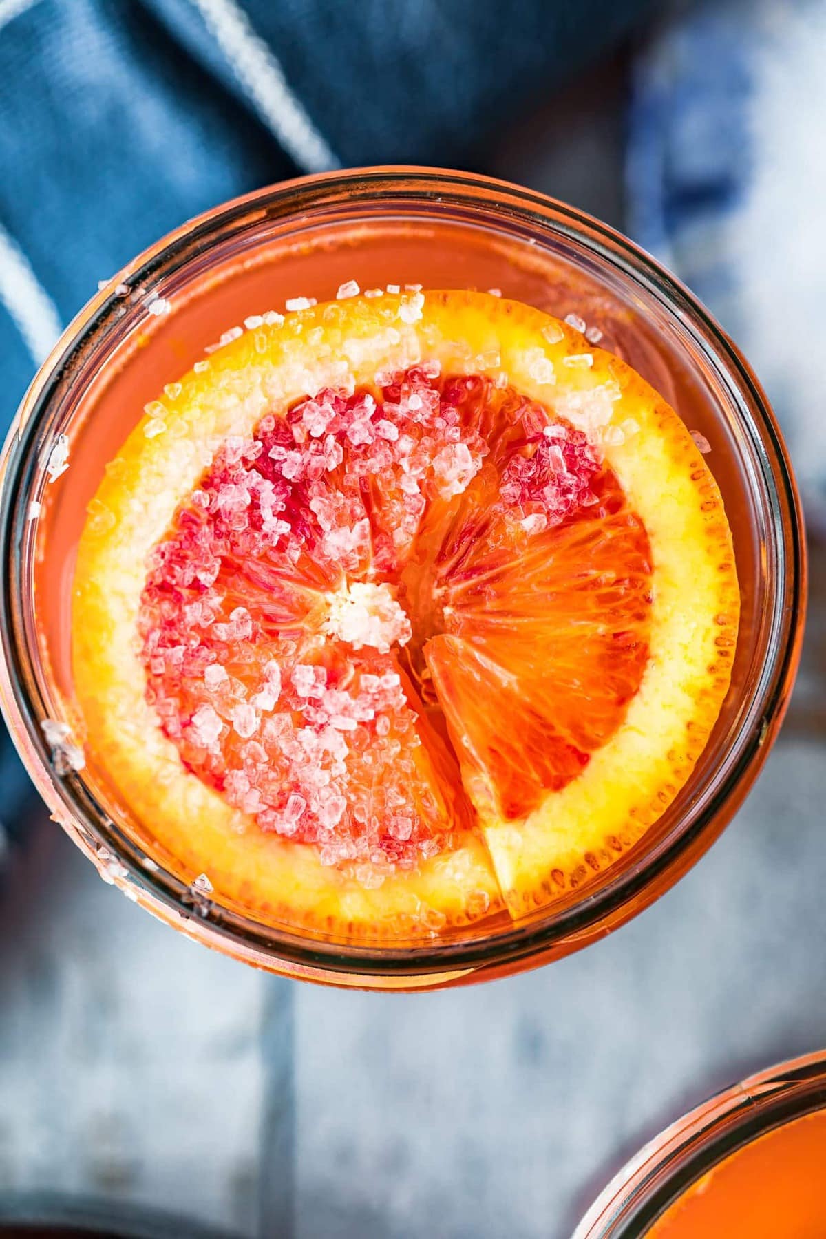 Top down shot of a salted orange slice in a paloma cocktail