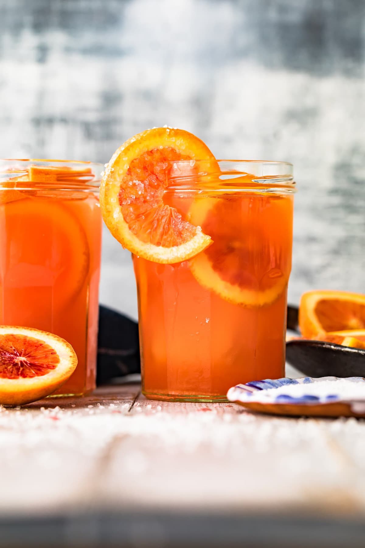 Two blood orange paloma cocktails served in mason jars
