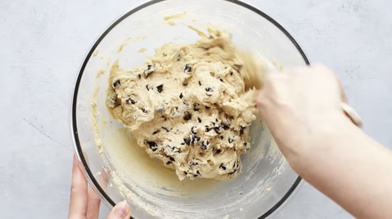edible chocolate chip cookie dough in a bowl with a rubber spatula.