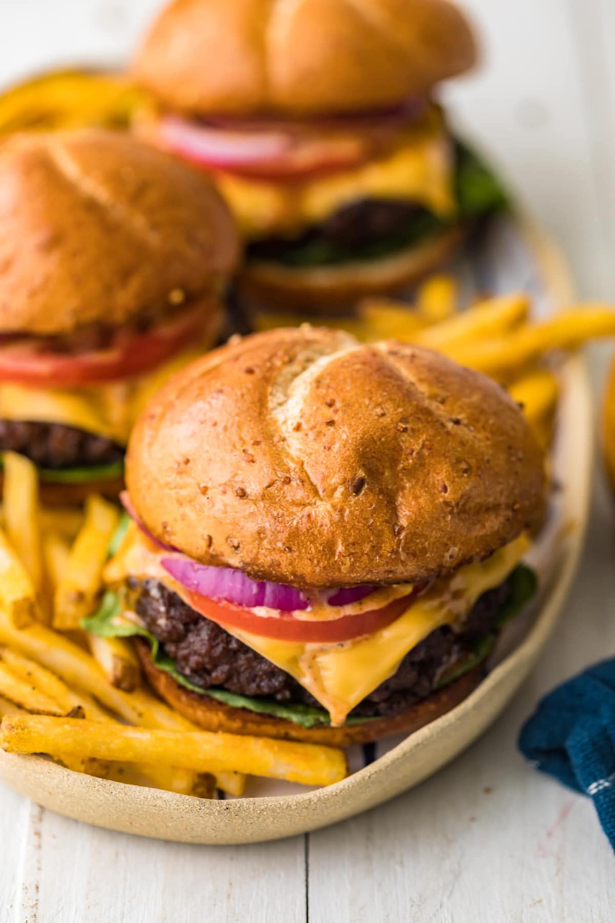 A juicy grilled burger served with fries on a platter