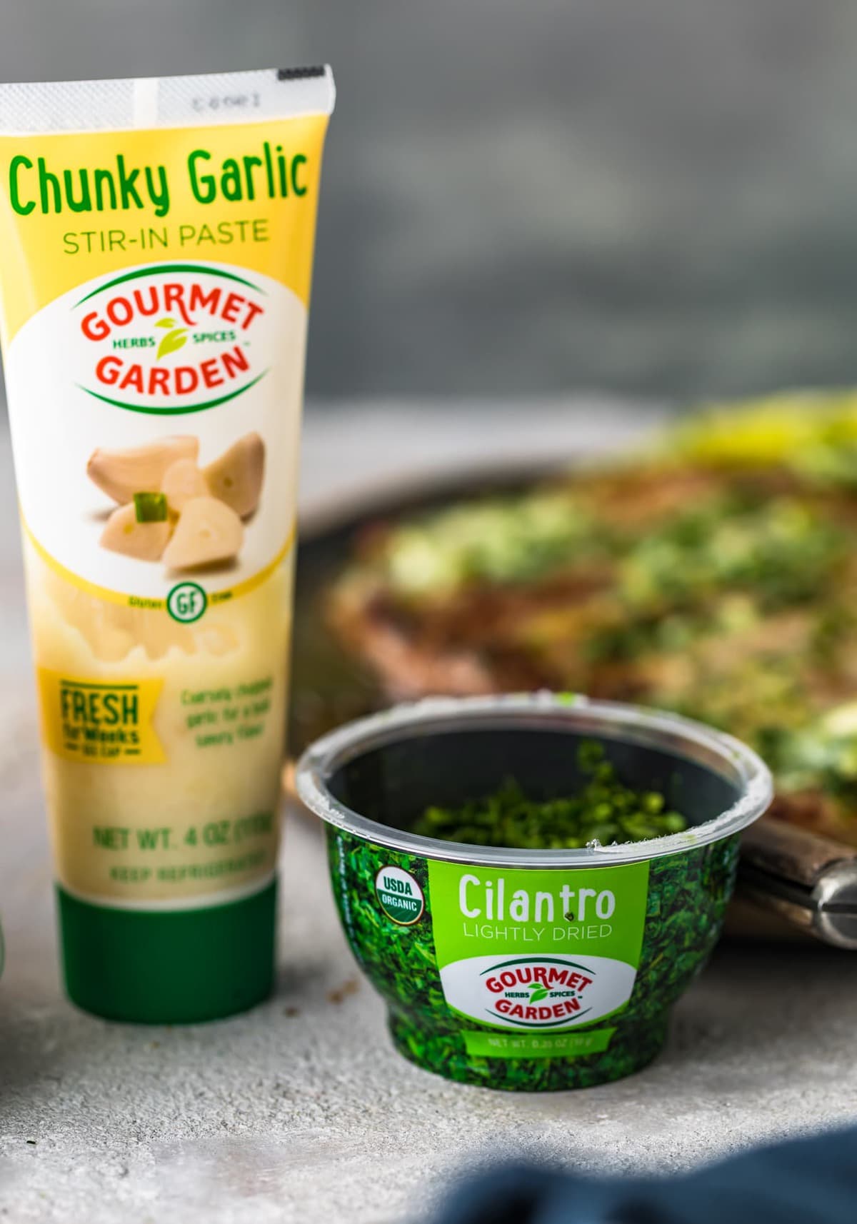 tube of gourmet garden garlic paste and container of cilantro