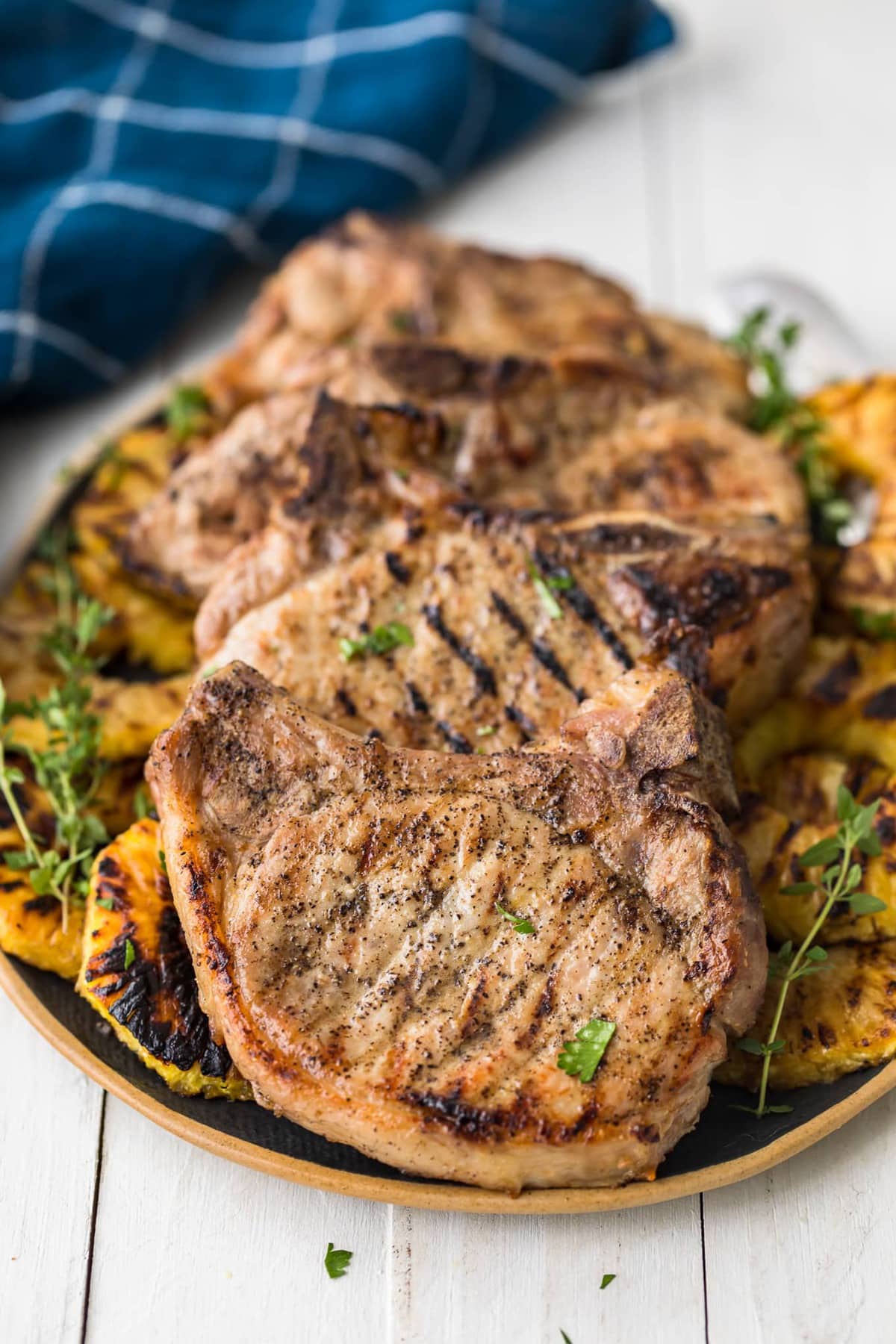Close up of grilled pork chops on top of grilled pineapple