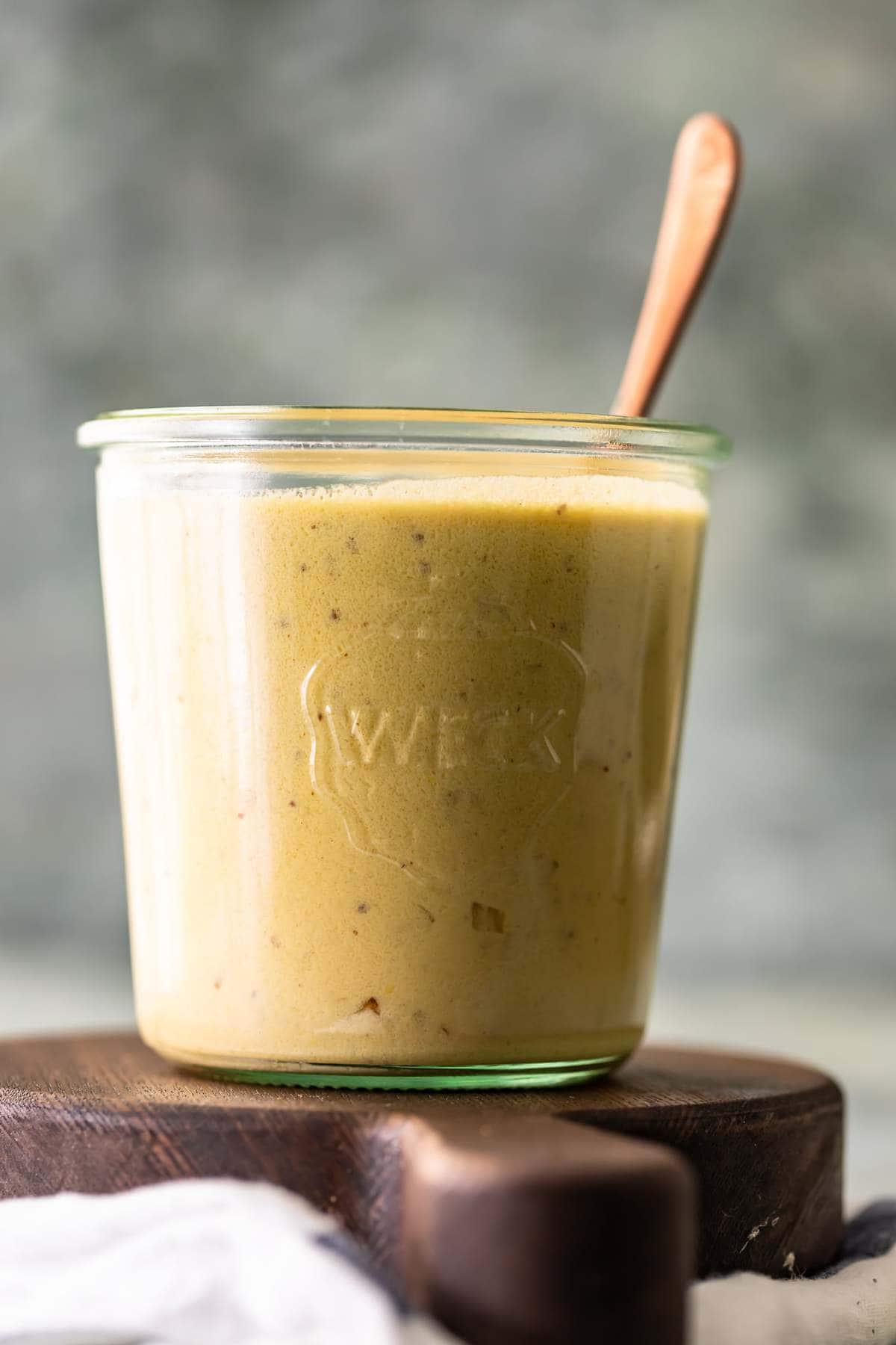 Side view of mustard cream sauce in a glass jar