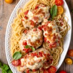 overhead shot of bruschetta chicken on top of pasta on plate