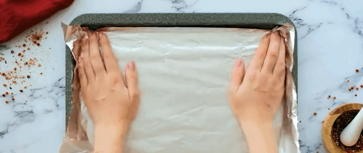 Lining a cookie sheet with aluminum foil.