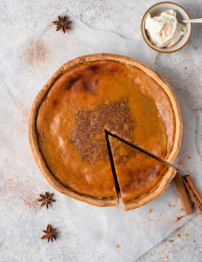 pumpkin pie next to cinnamon sticks