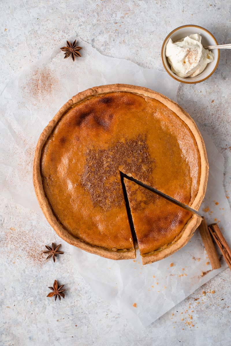 It wouldn't be Fall without a Homemade Pumpkin Pie and this pie is without a doubt the best I've ever tasted and is super easy to whip up! #pumpkinpie #dessert Pumpkin Pie with one slice pulled out.