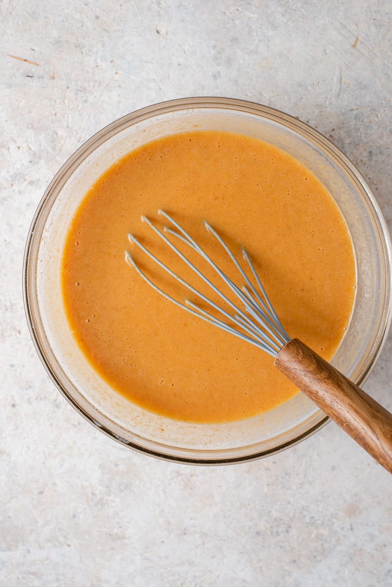 It wouldn't be Fall without a Homemade Pumpkin Pie and this pie is without a doubt the best I've ever tasted and is super easy to whip up! #pumpkinpie #dessert Homemade pumpkin pie filling in a bowl with a whisk.