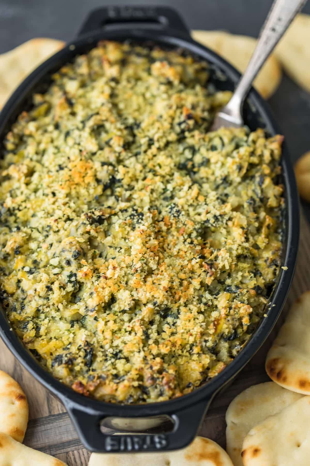 Spinach dip baked in a black skillet.