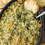 spinach dip in casserole dish with chip