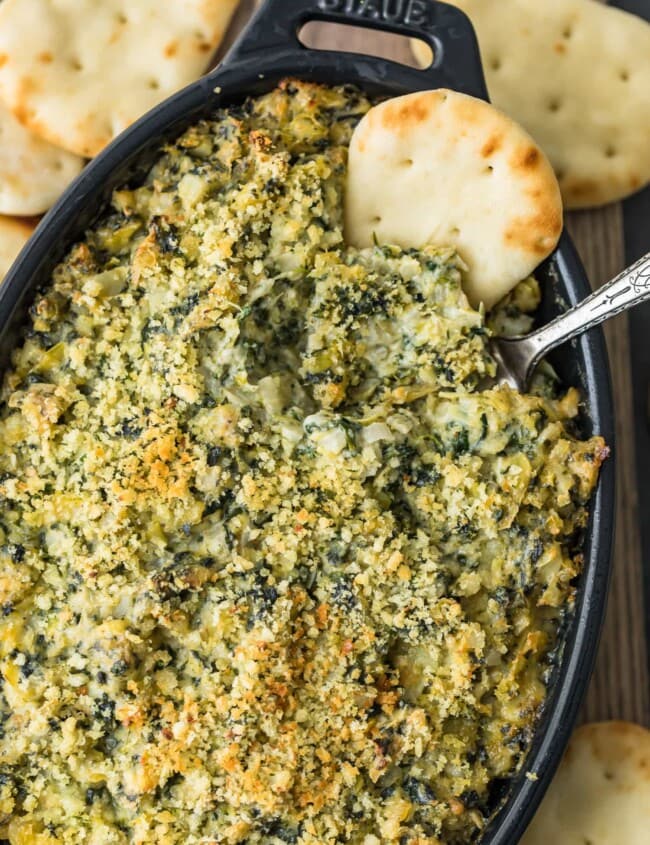 spinach dip in casserole dish with chip