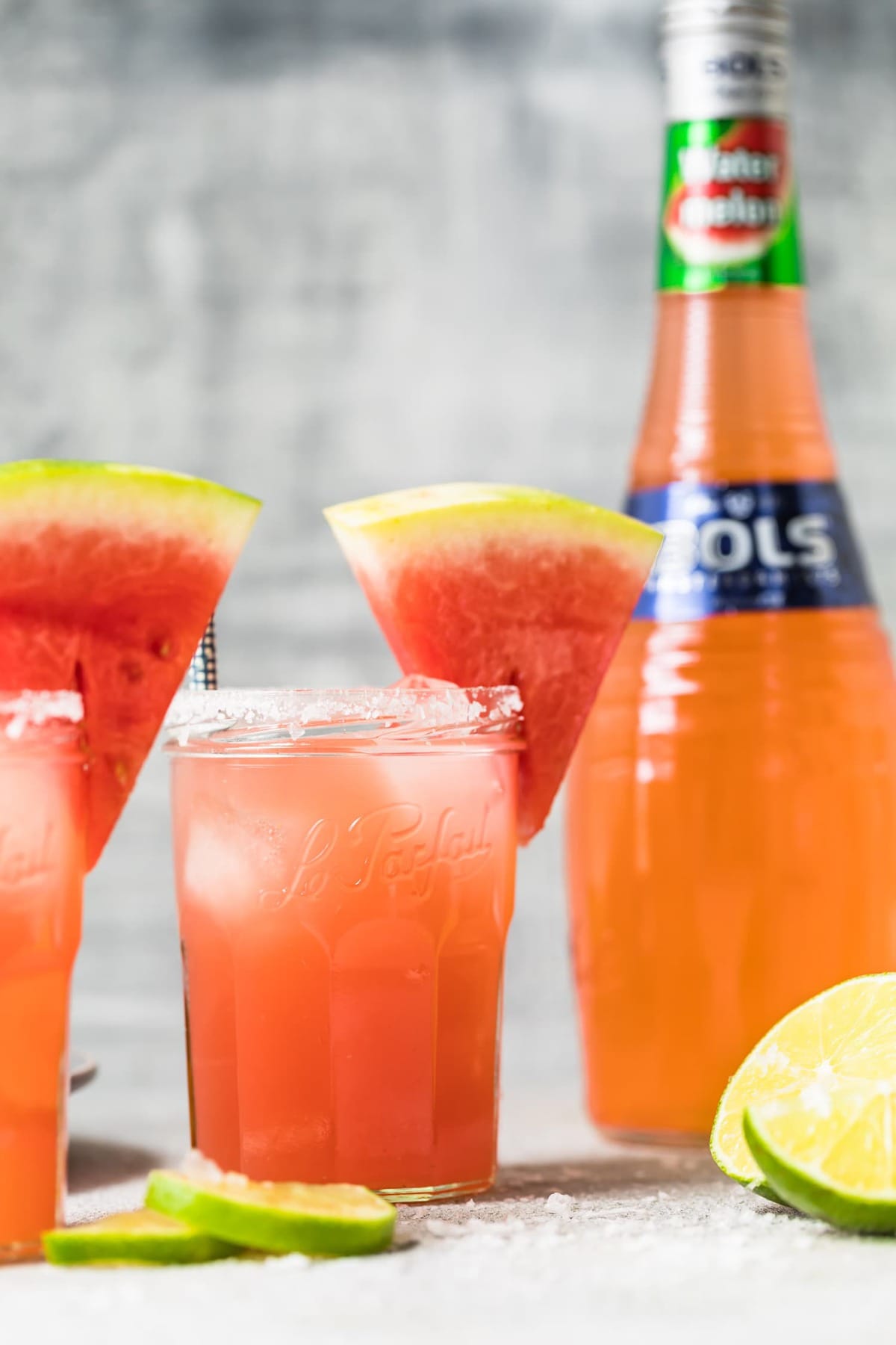 watermelon cocktail next to a bottle of watermelon liqueur