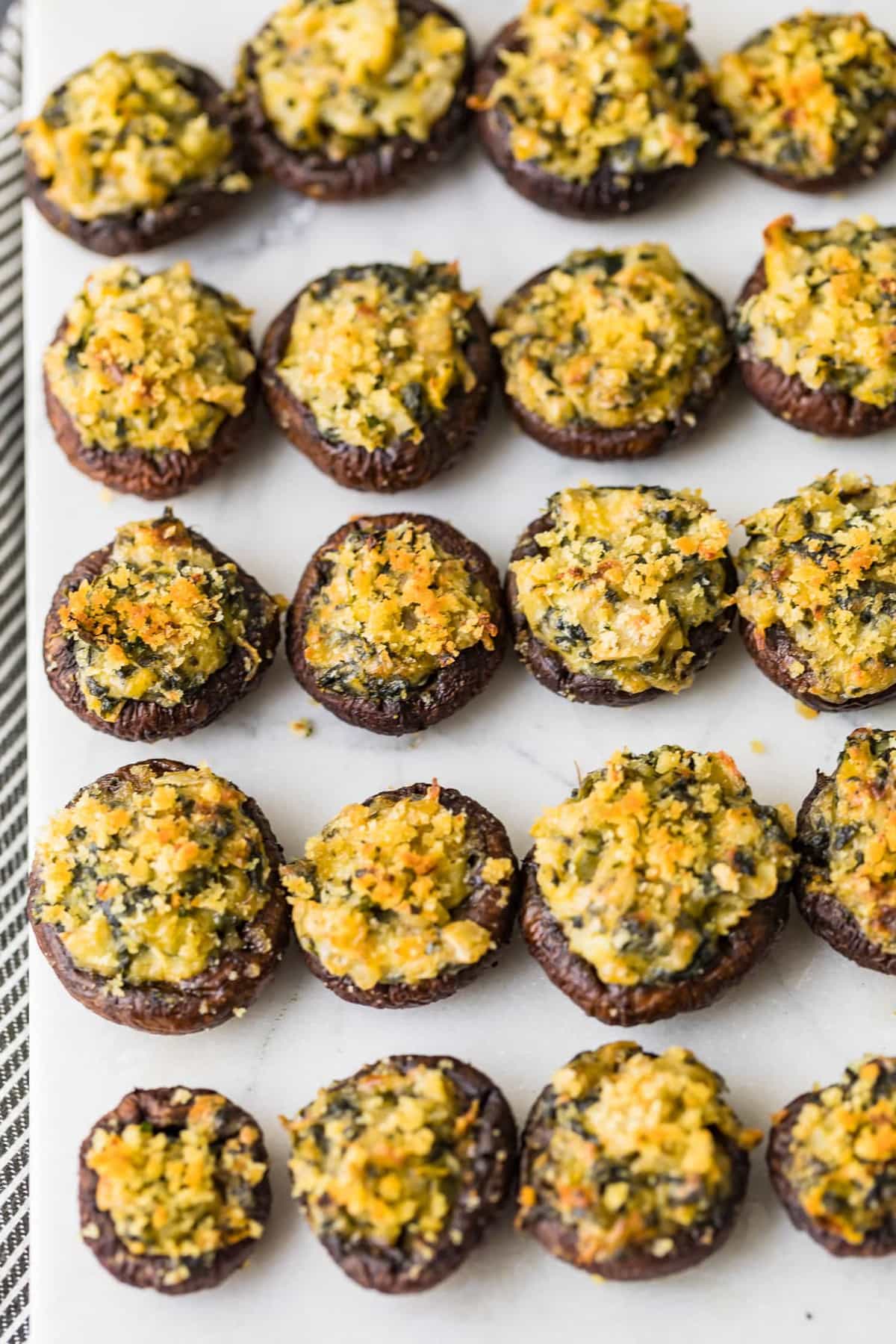 Spinach Stuffed Mushrooms on a white cutting board