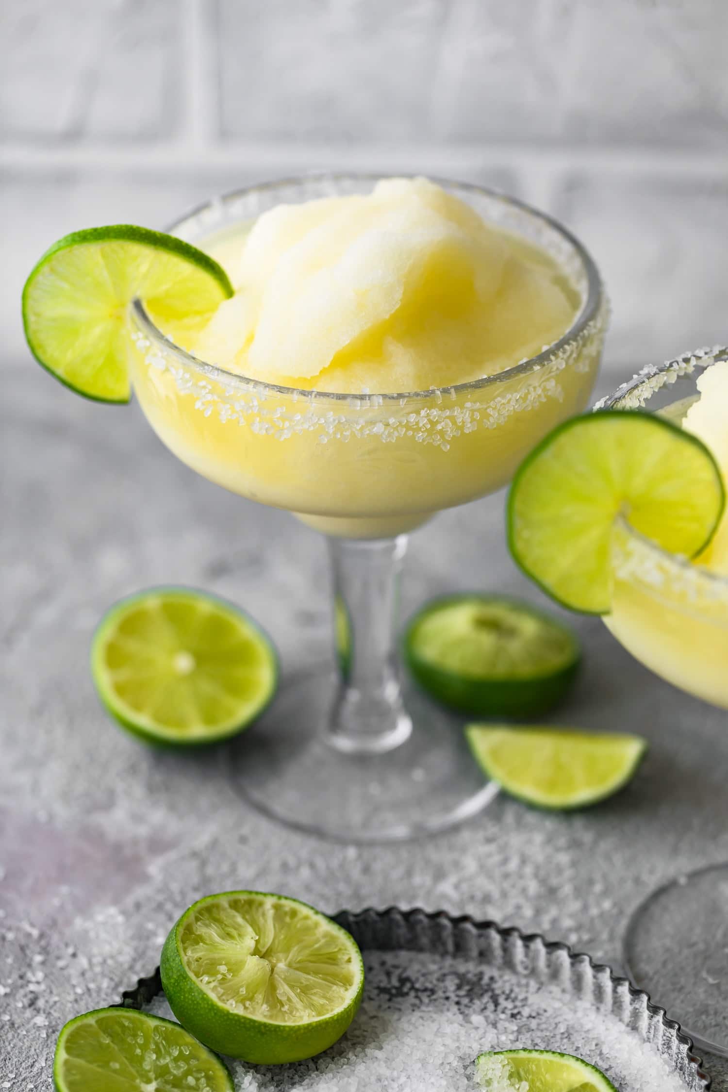 Margarita cocktail in a glass next to lime halves