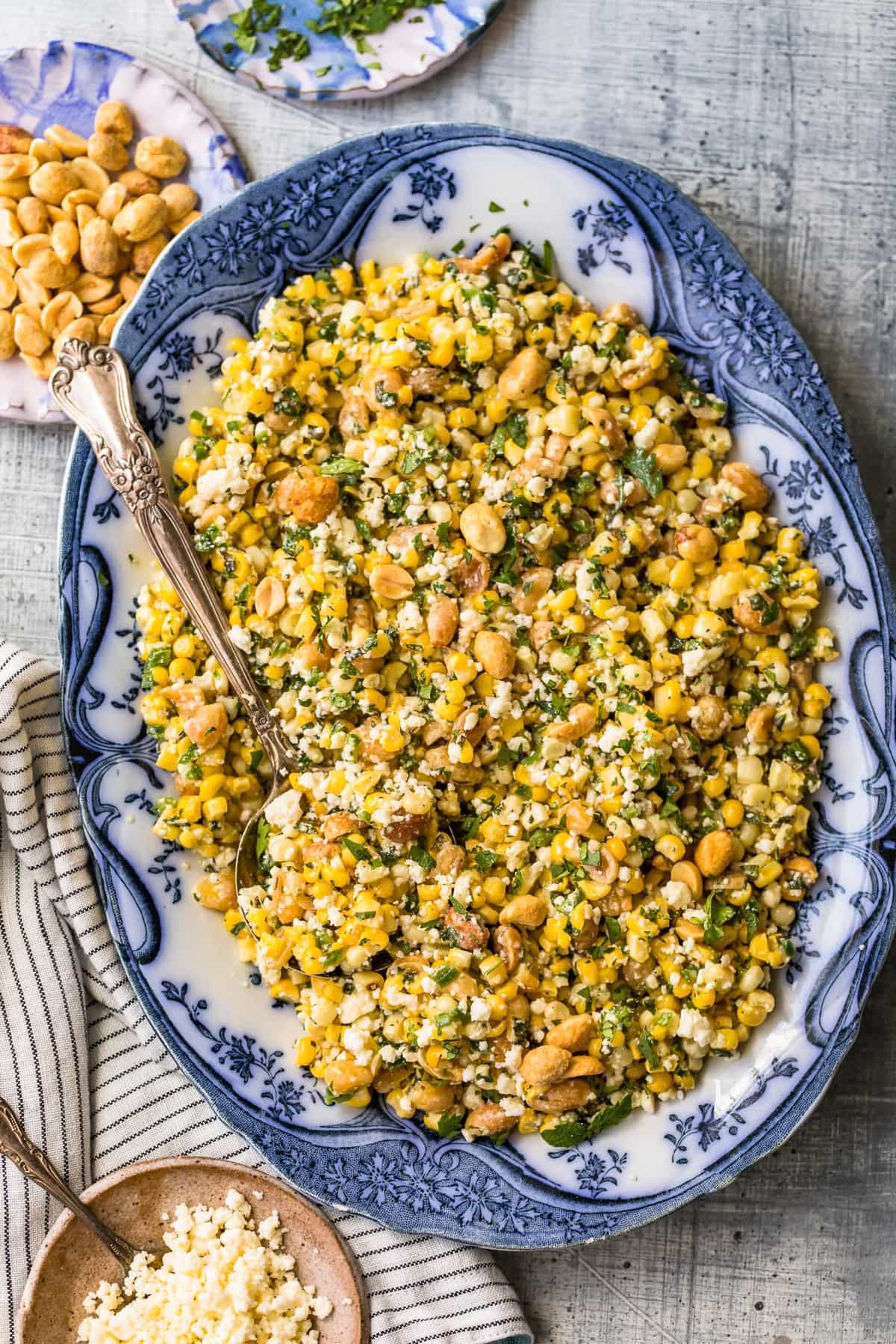 Grilled corn salad on a large serving plate with a spoon