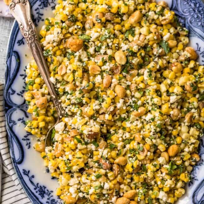 a plate with blue and white colors showcasing a delicious combination of grilled corn salad and peanuts.