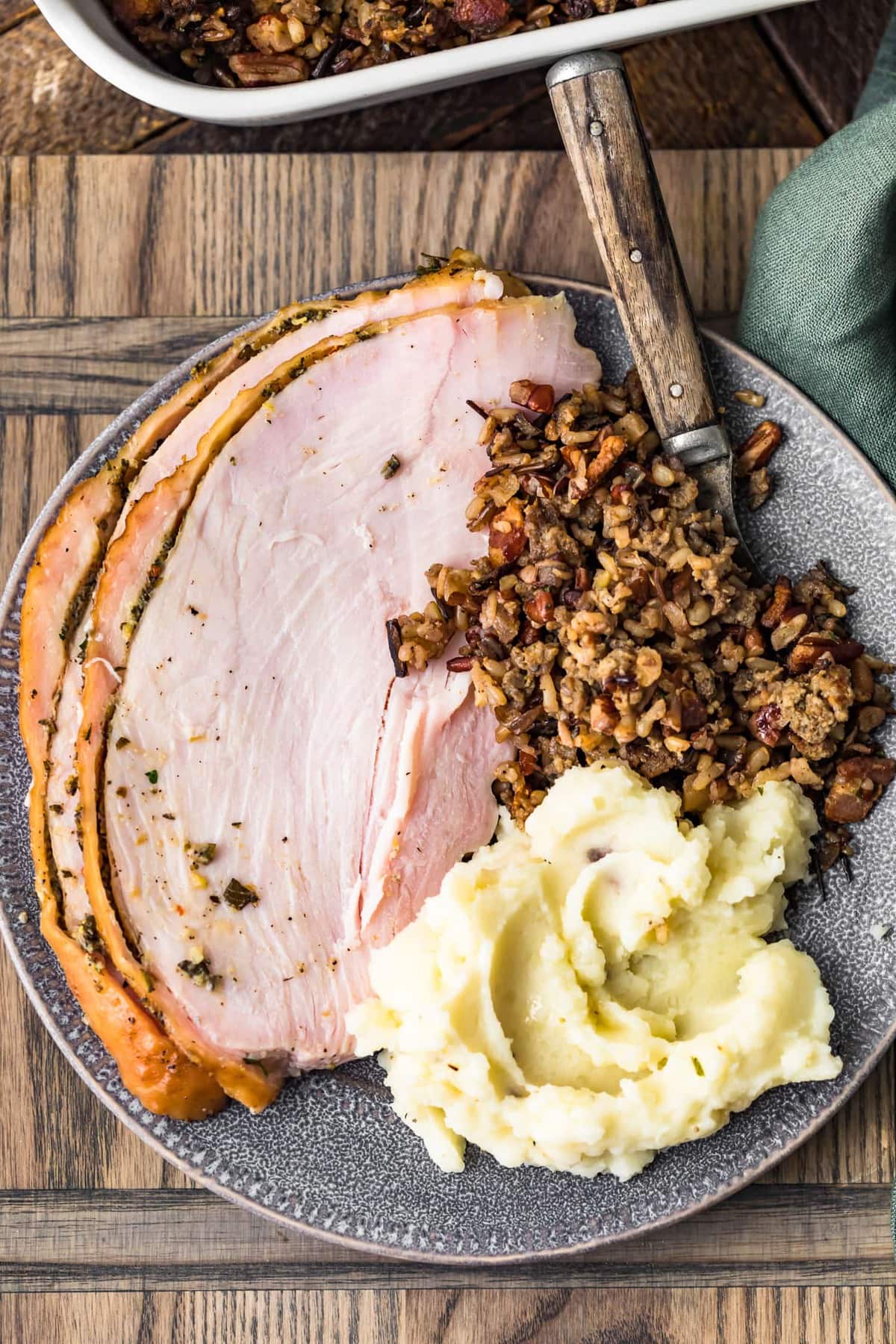 Two slices of smoked turkey breast served with stuffing an potato