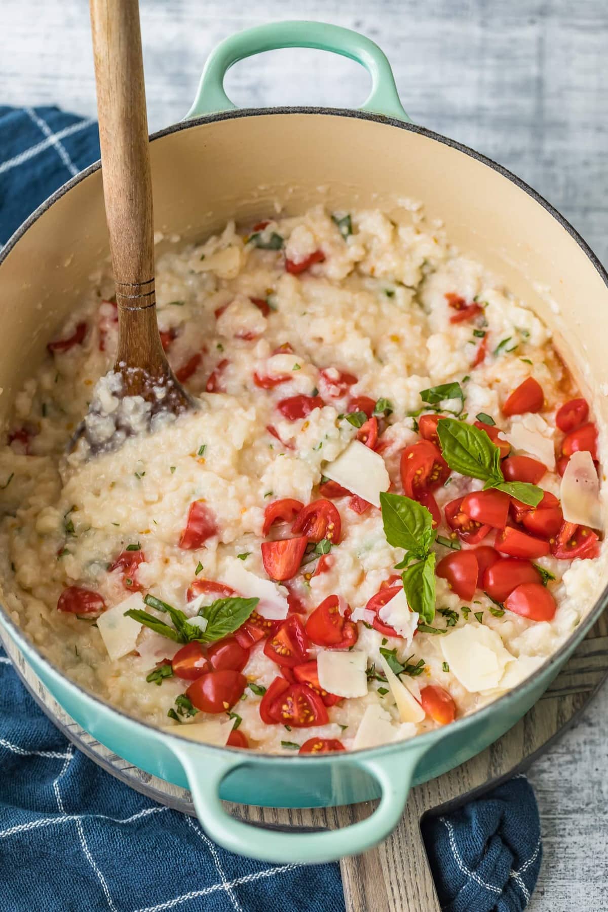 A wooden spoon in a dutch oven with the cooked rice