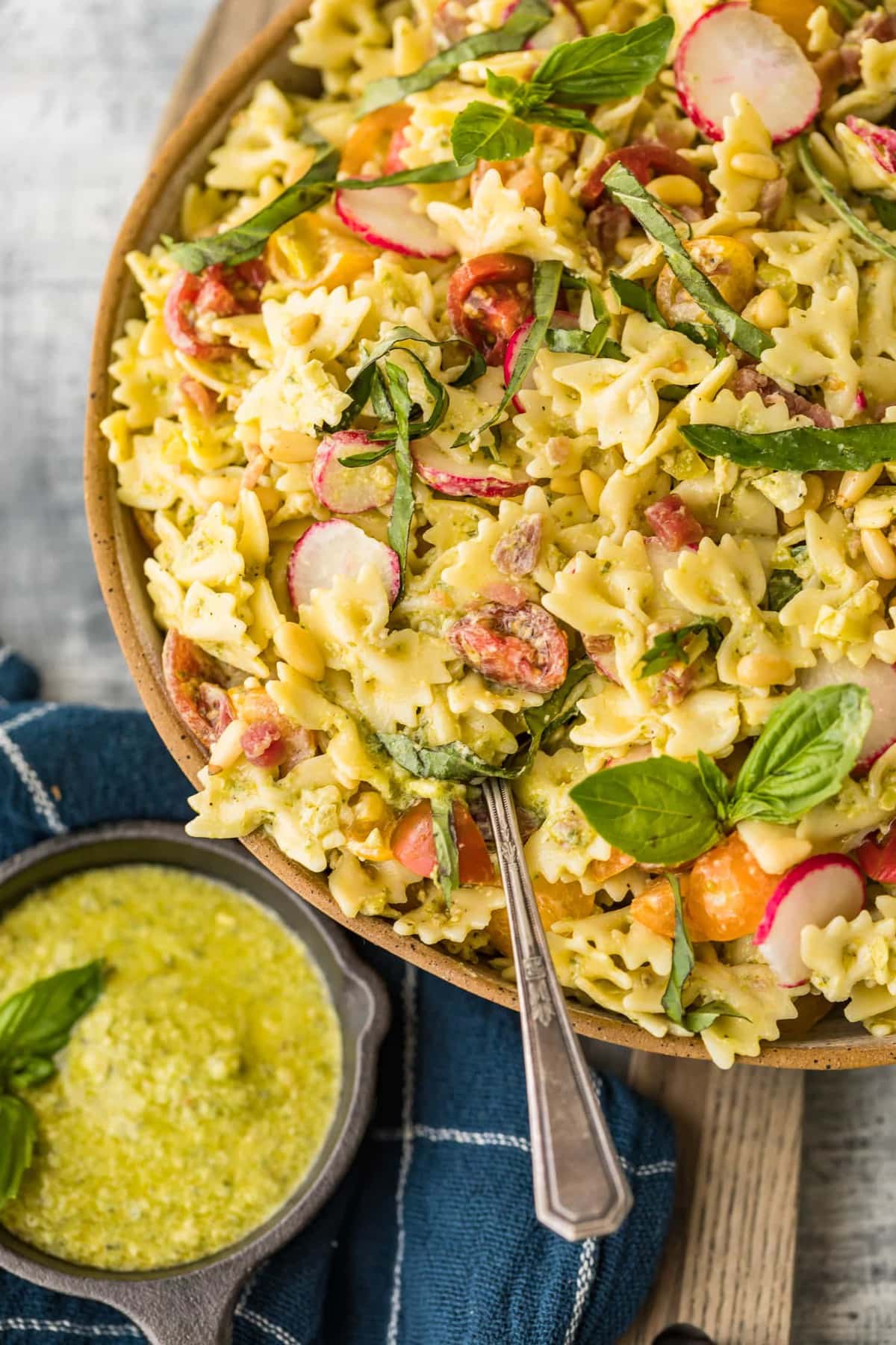 A spoon in pesto pasta salad