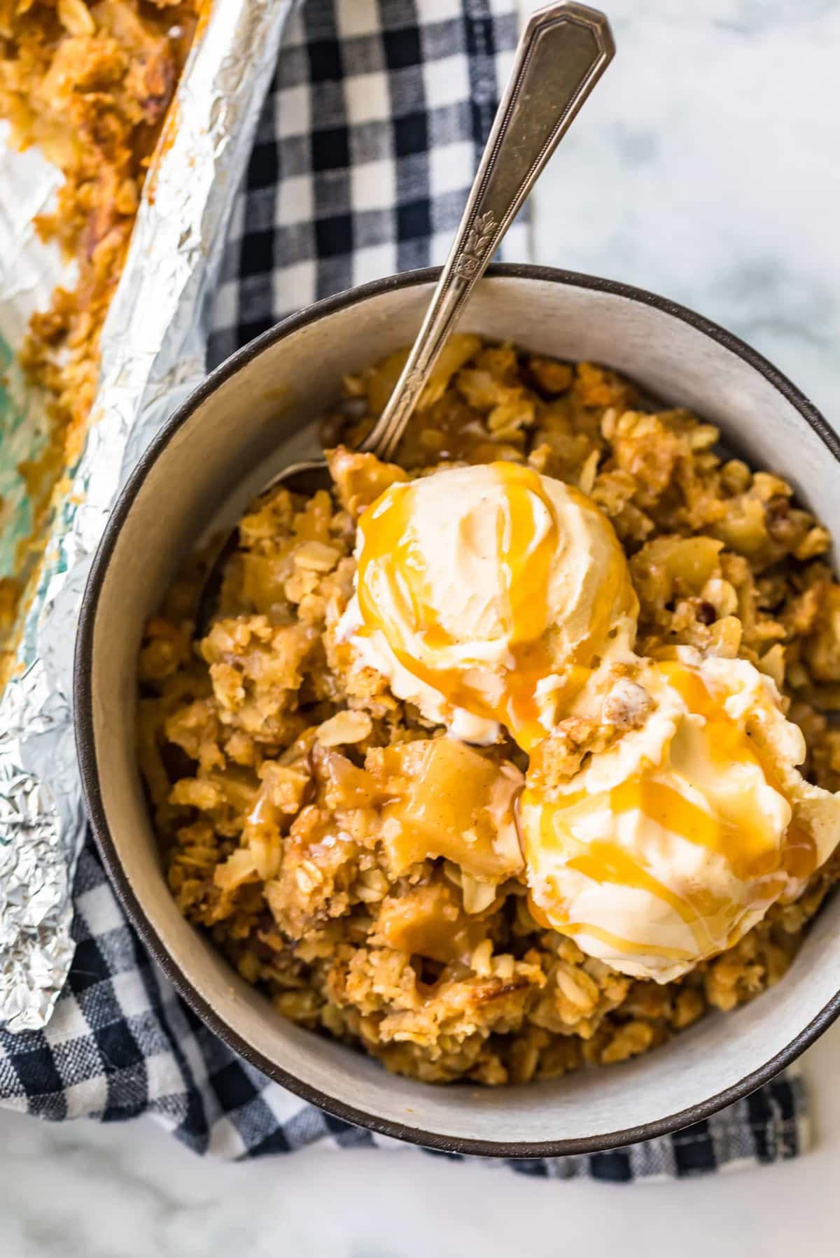 Apple dessert in a white bowl with ice cream