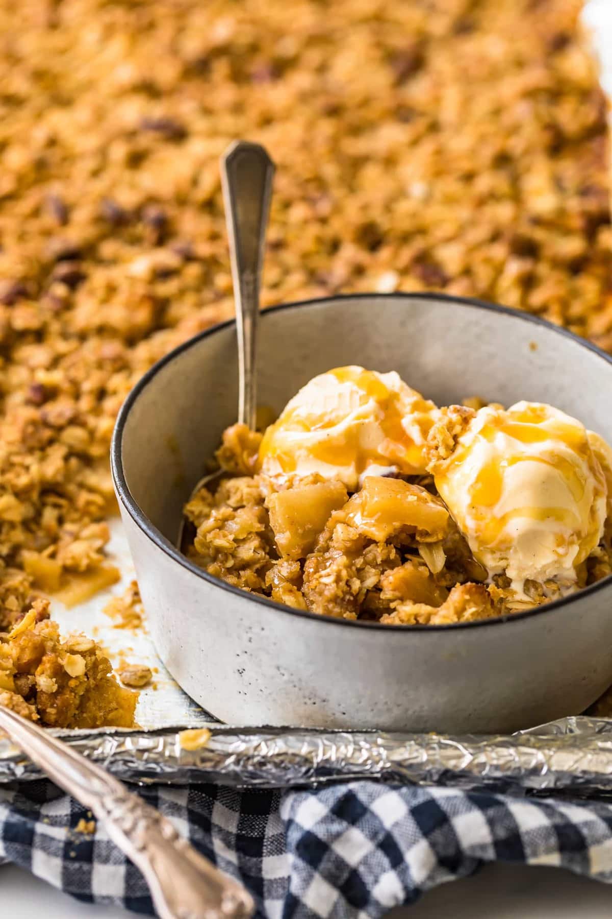 A spoon in a bowl with dessert and ice cream