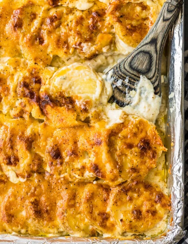 sheet pan scalloped potatoes in a pan with spoon