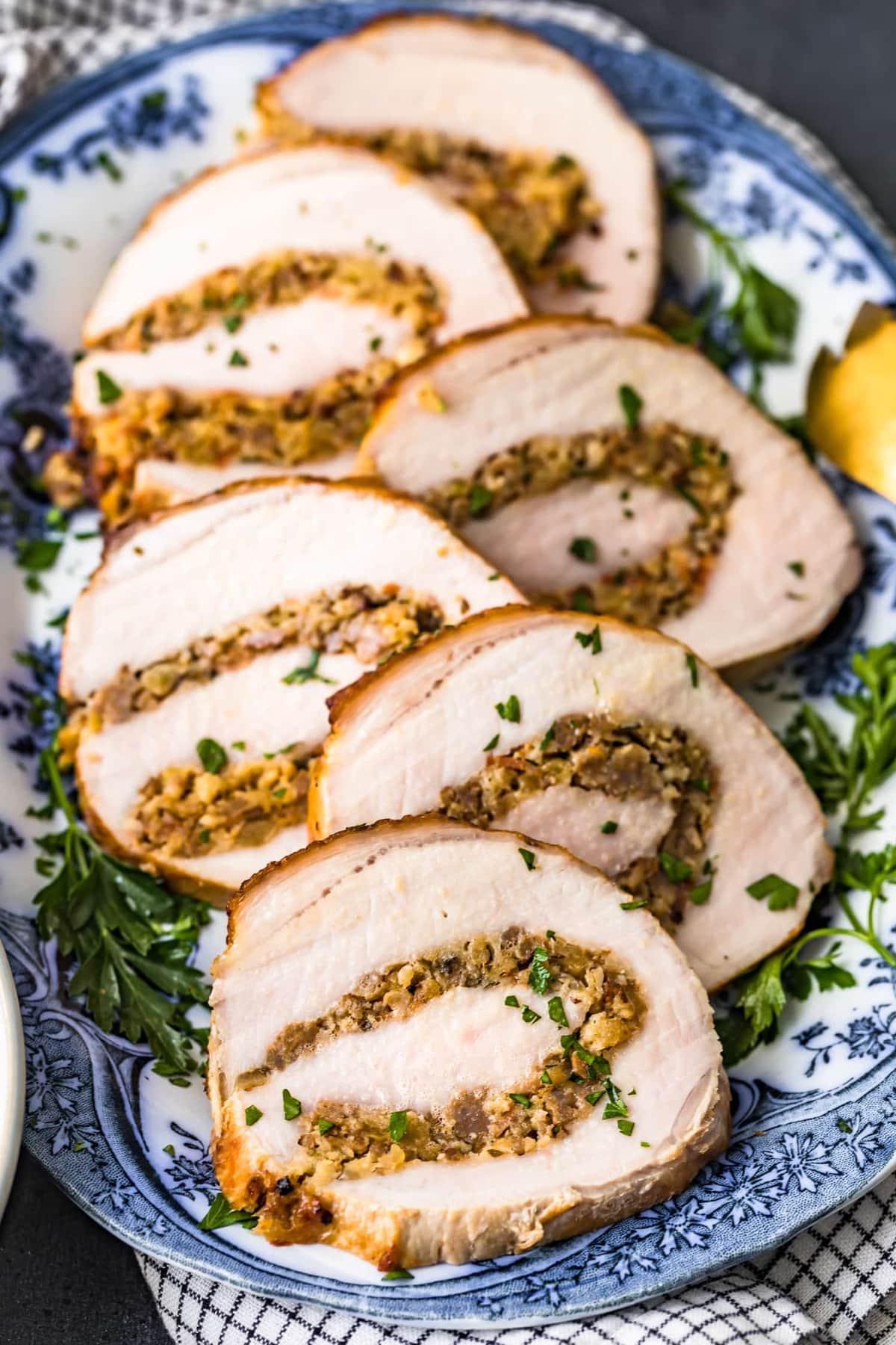 The meat on a serving platter garnished with fresh herbs