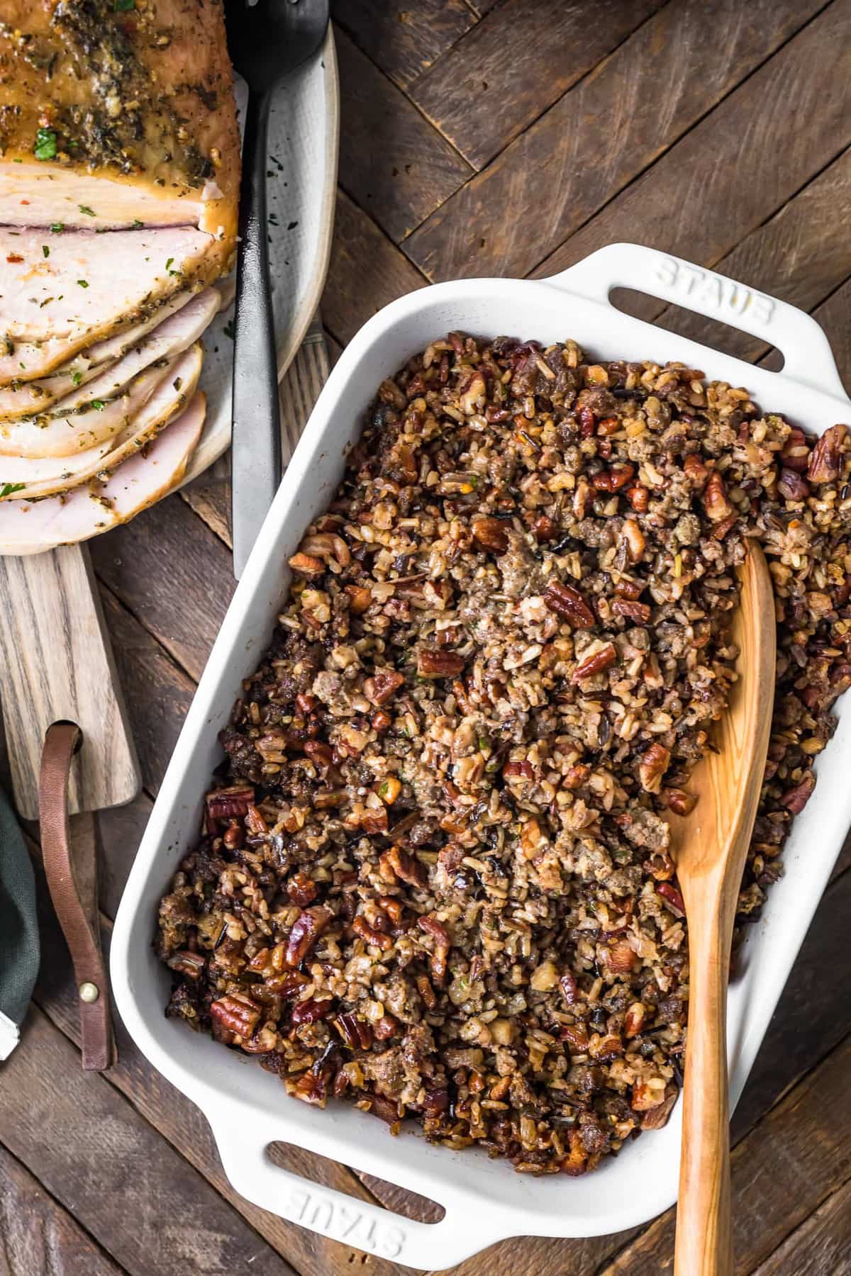 Wild Rice Sausage Stuffing in a dish with a wooden spoon