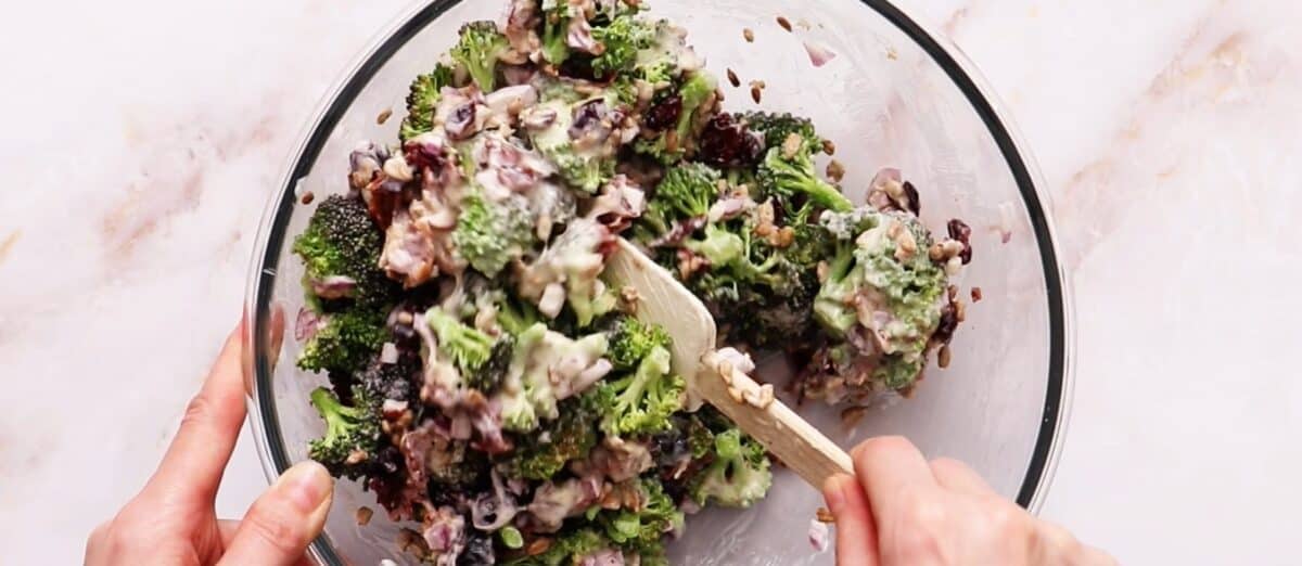 Tossing the dressing with the salad.