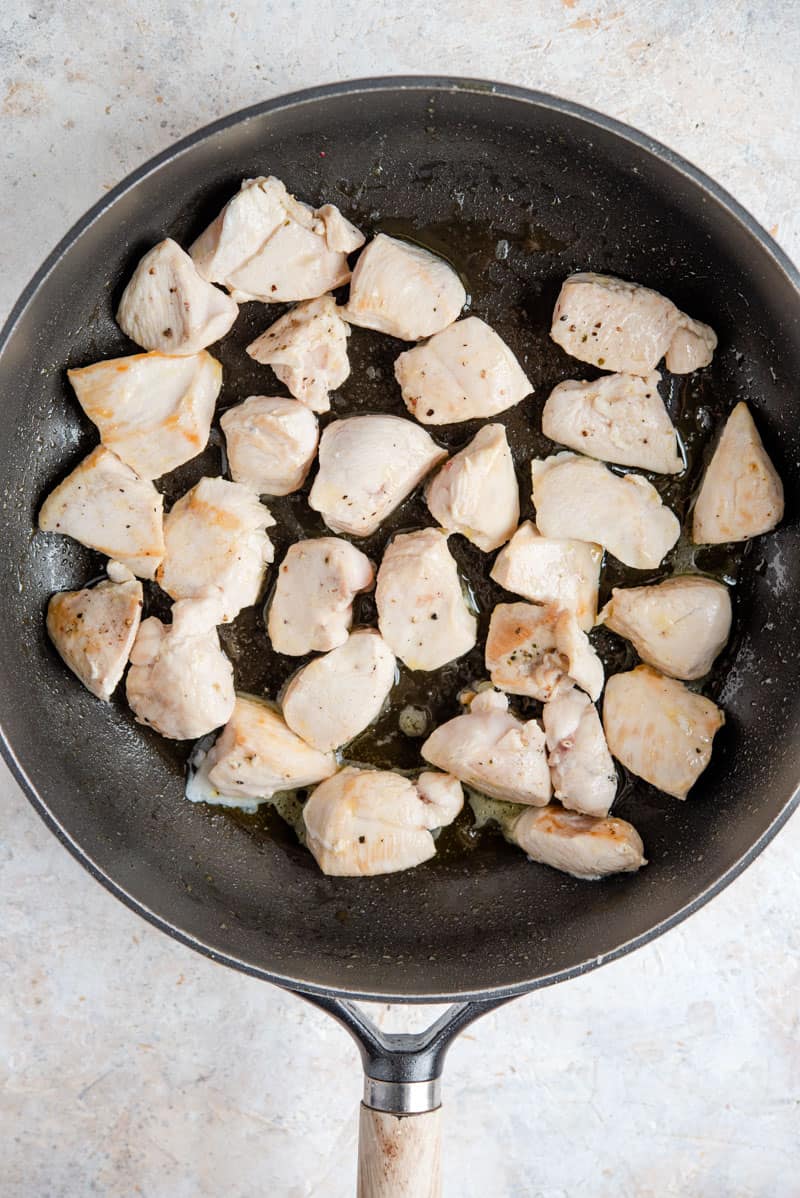 Browning chicken in a pan for making one pot chicken alfredo