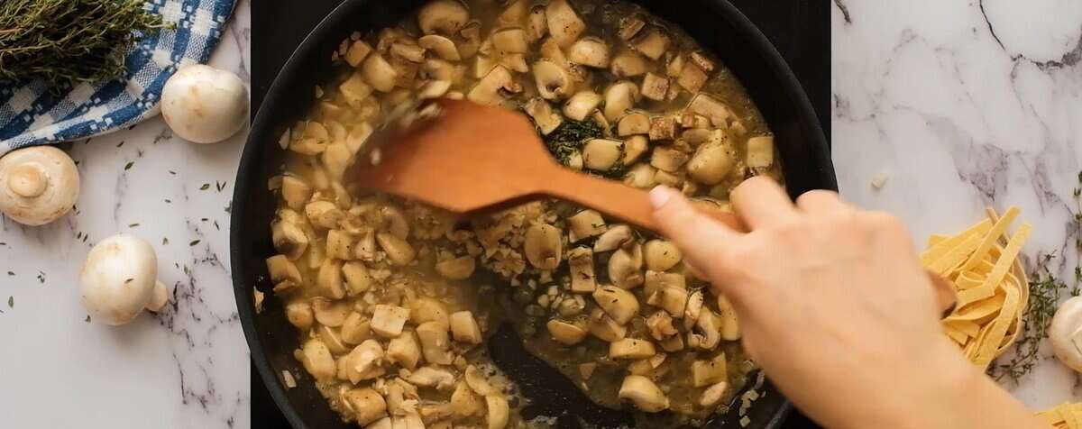 Adding wine and seasoning to the mushrooms.