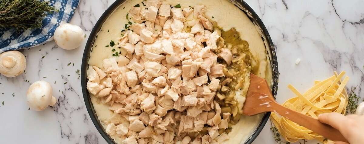 Combining the sauce with the chicken and vegetables.