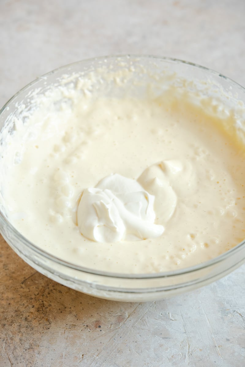 The filling for making caramel cheesecake in a mixing bowl