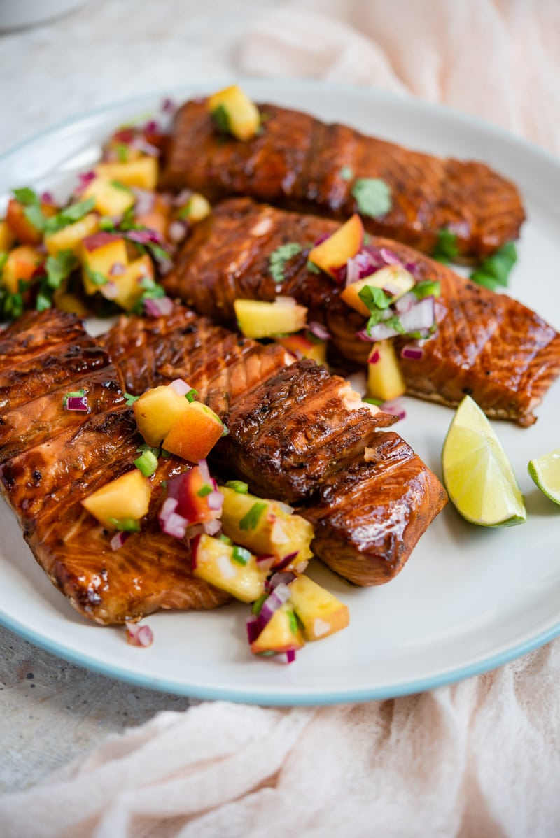 Grilled salmon fillets on a plate with peach salsa