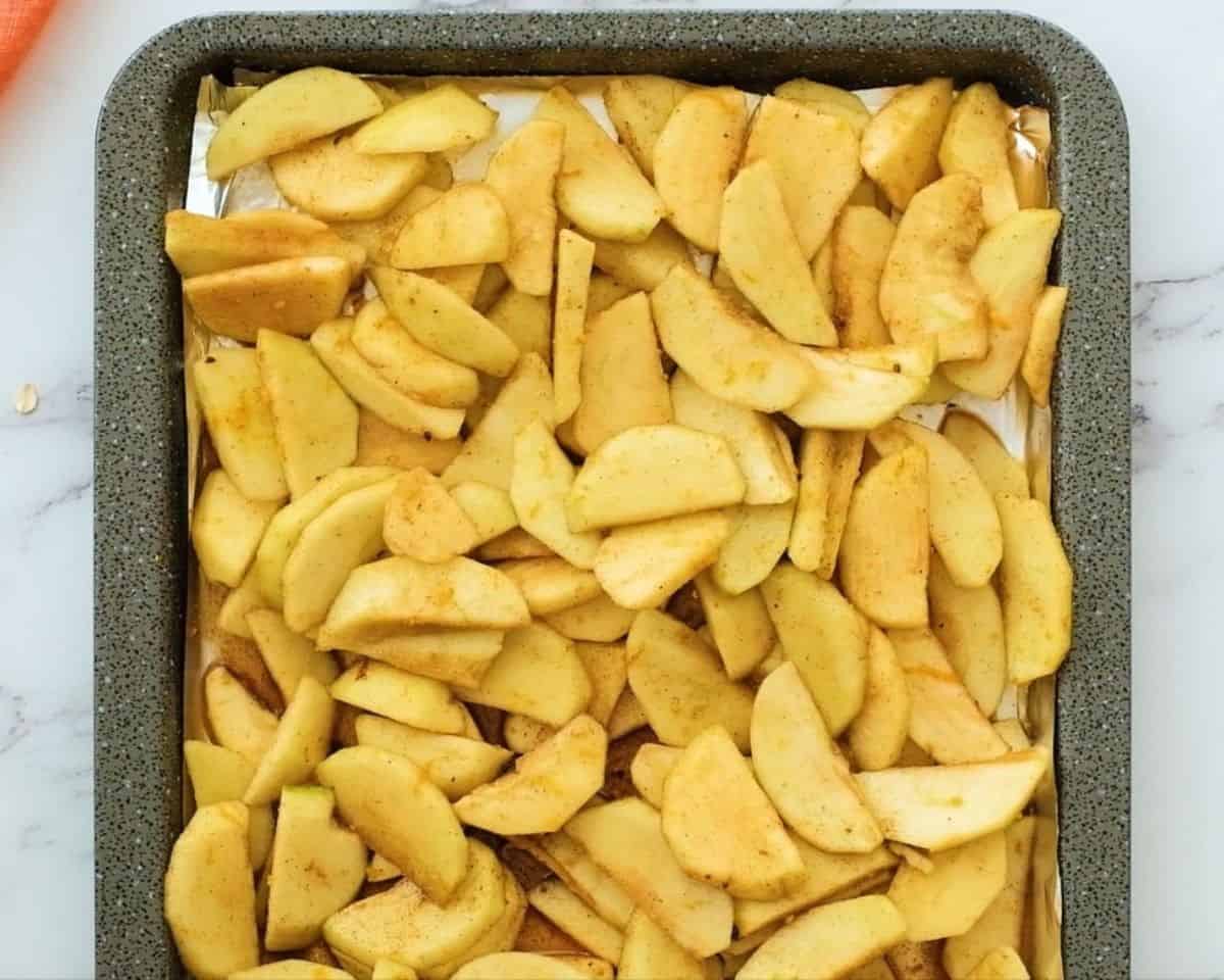 Sliced apples on a sheet pan.