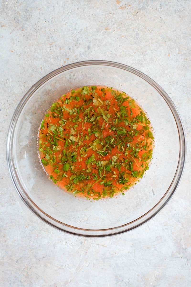 An overhead view of a chicken marinade in a bowl.