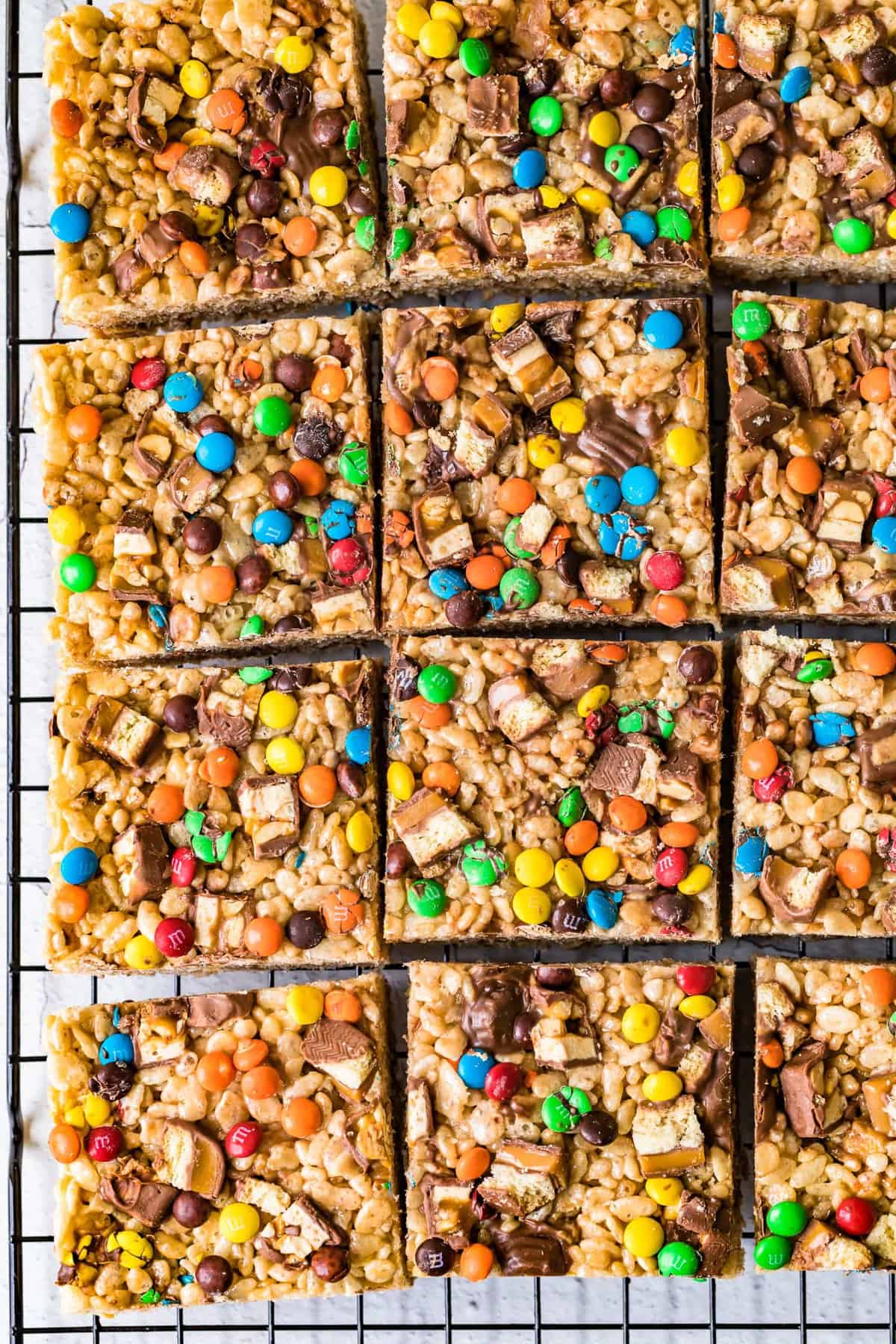 candy bar Rice Krispie treats cut into squares on cooling rack