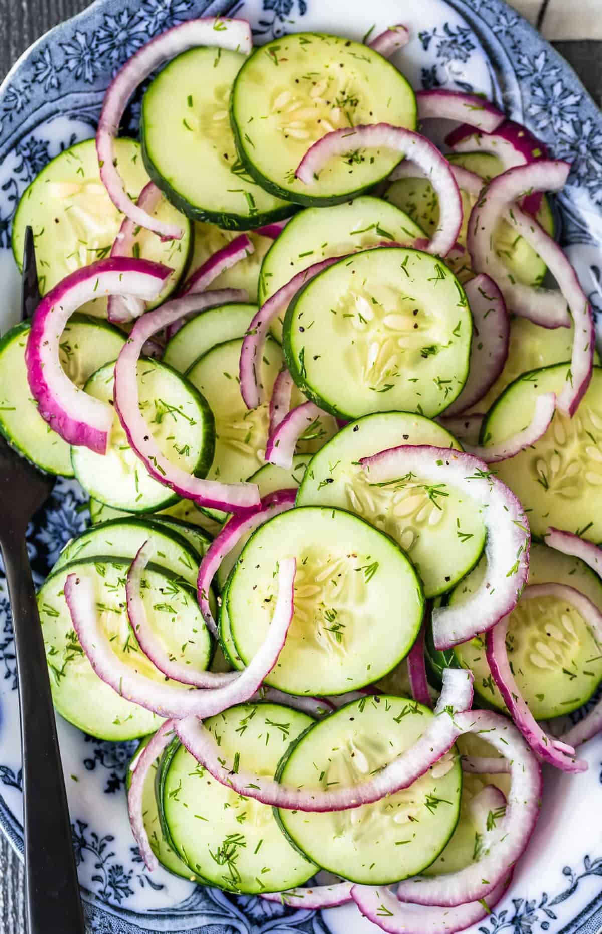 Salad with a fork on a blue and white plate