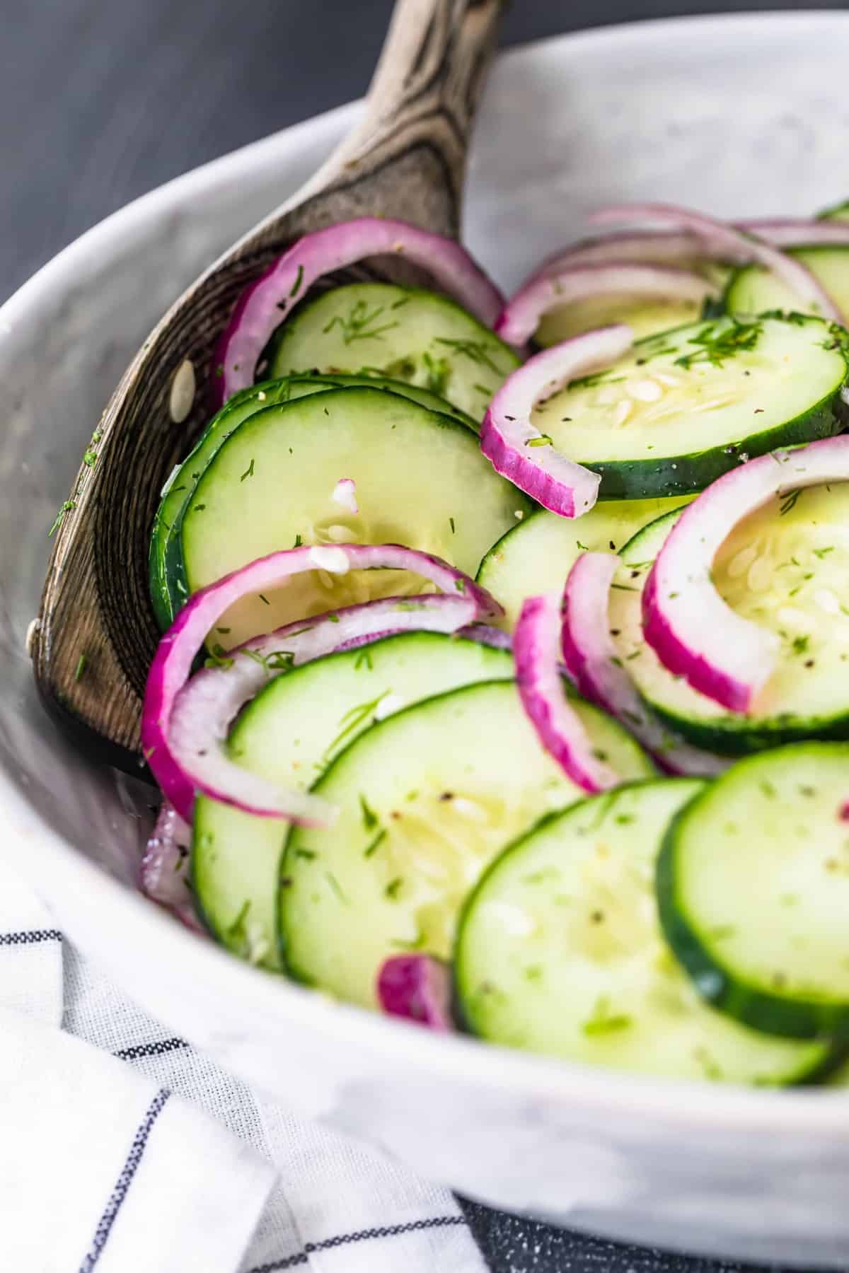 The finished salad in a white bowl with a wooden spoon