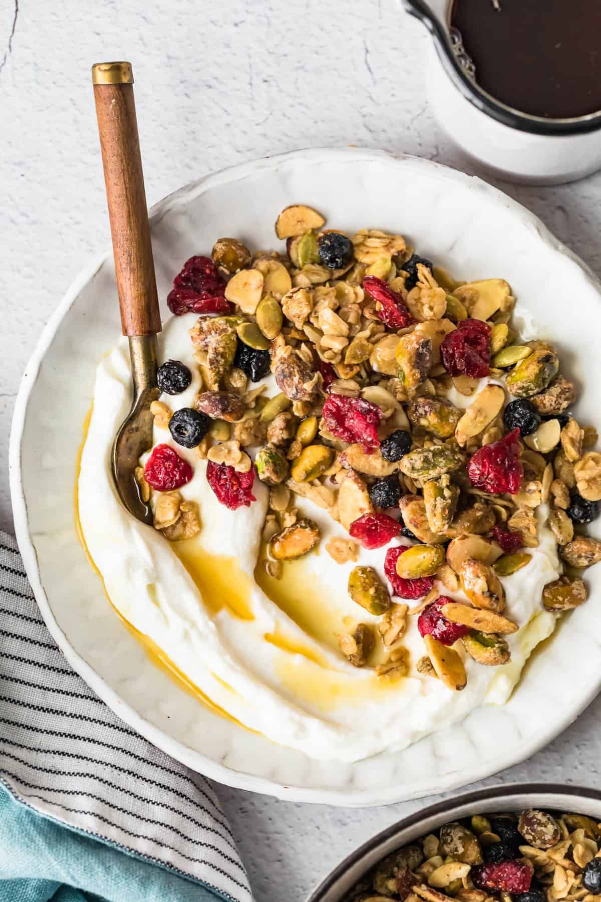 Maple syrup granola served with yogurt in a white bowl