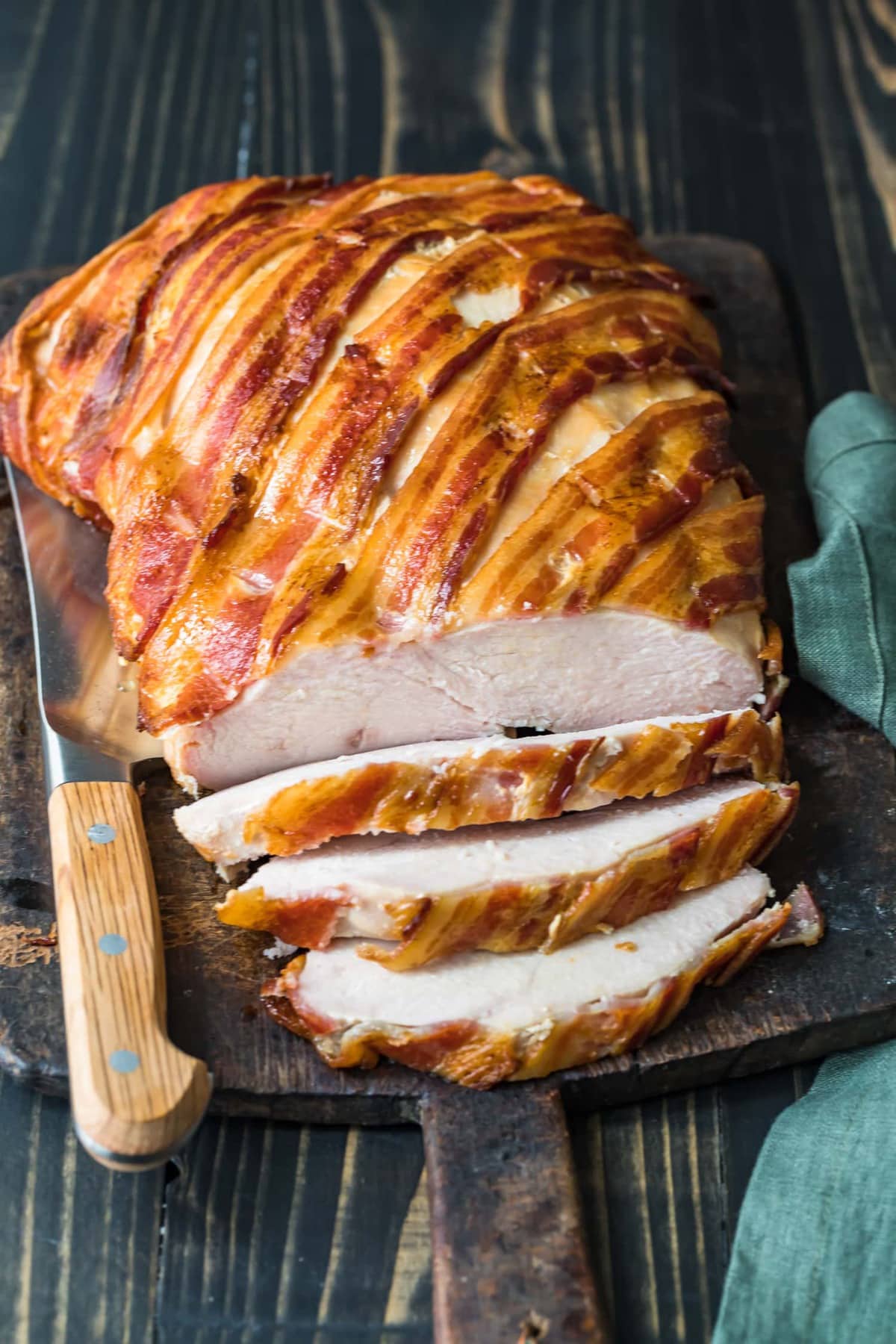 bacon wrapped turkey breast on a chopping board