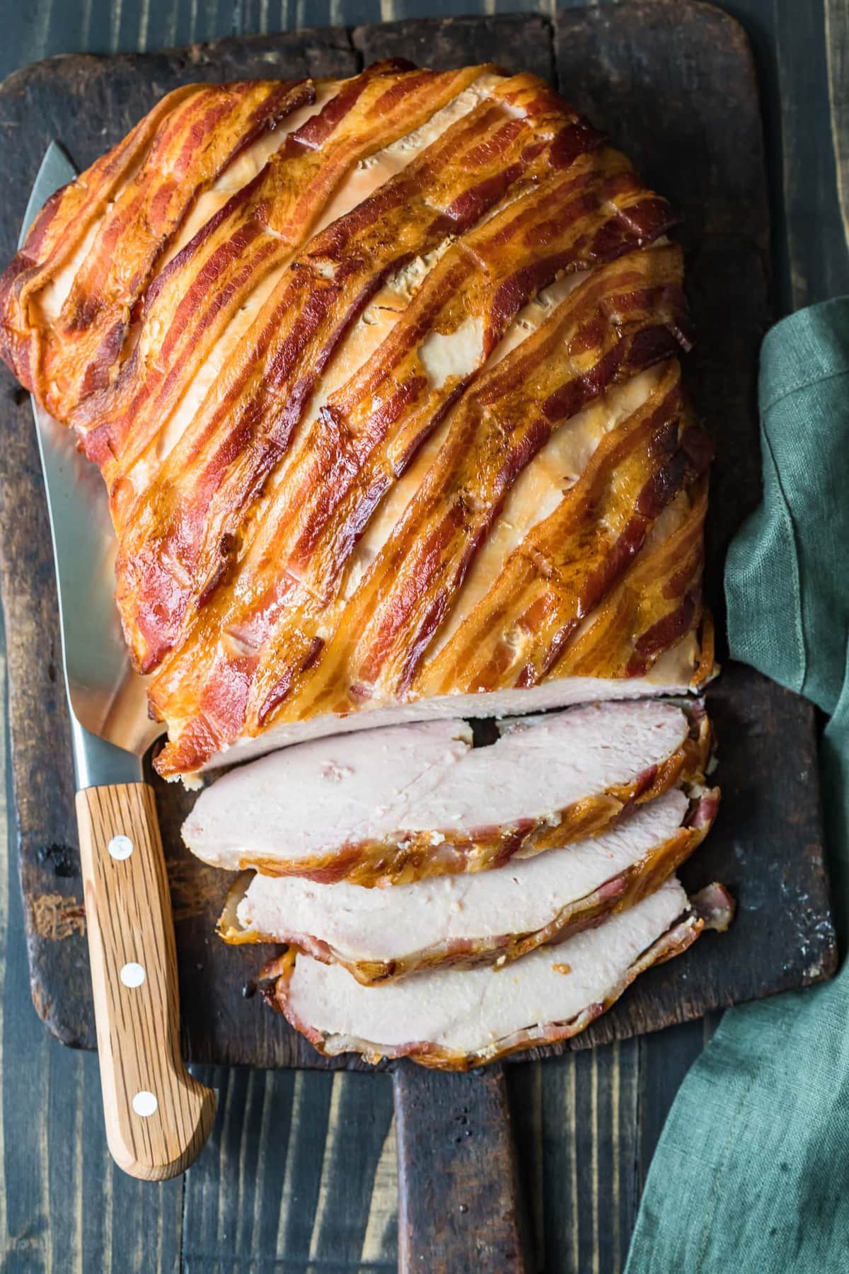 The cooked breast on a chopping board being sliced