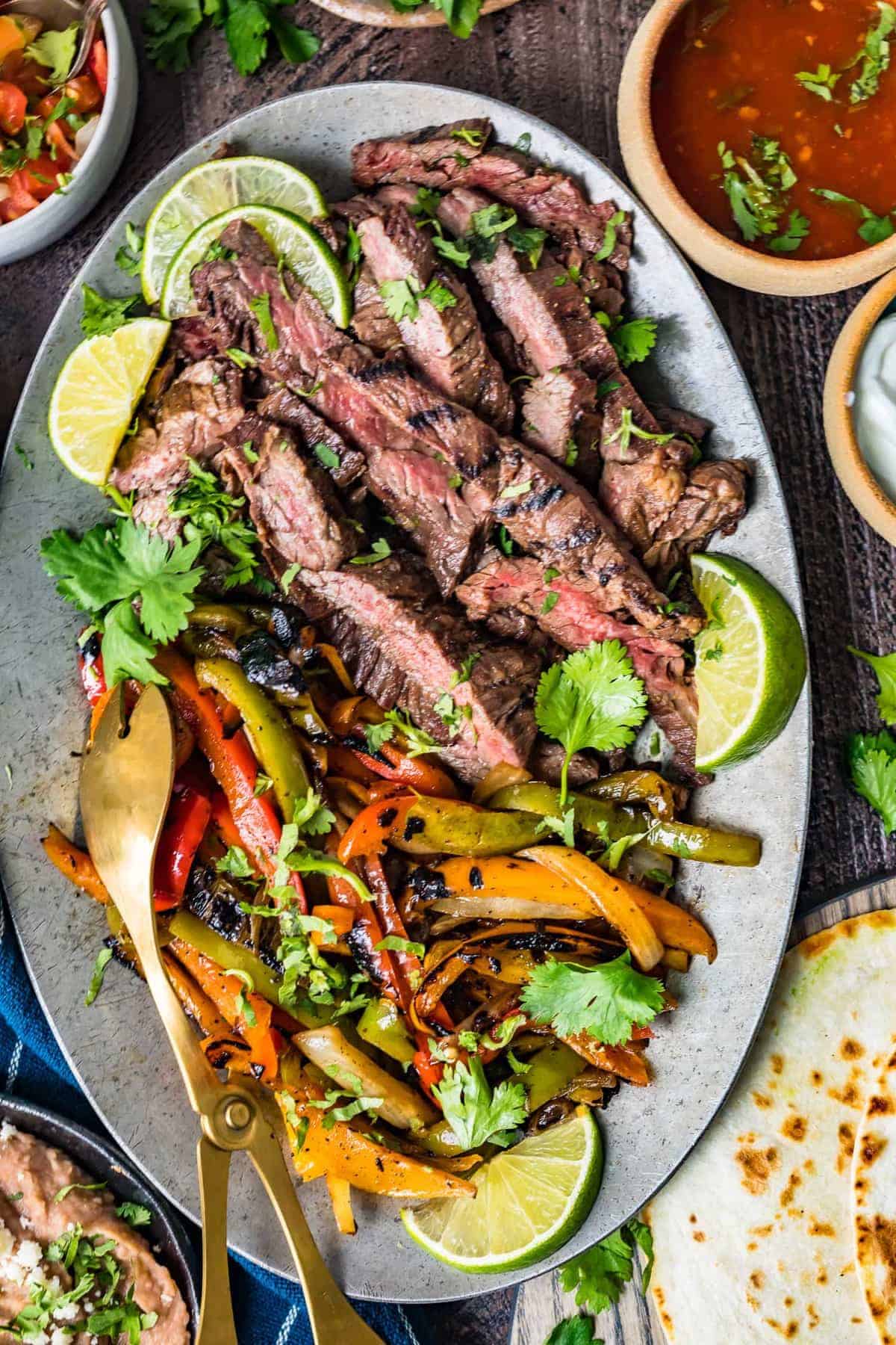 Steak fajitas served with lime wedges