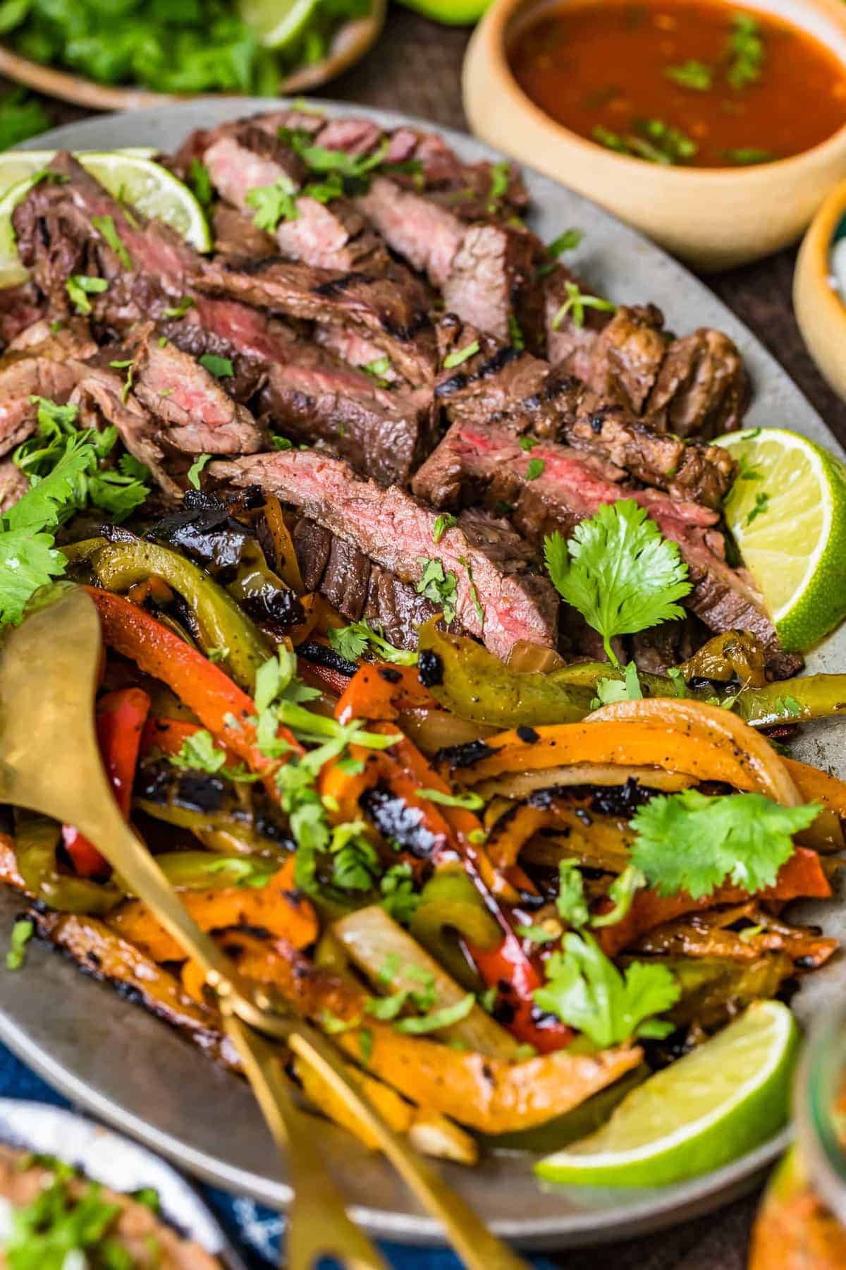 Strips of beef cooked medium rare next to grilled vegetables