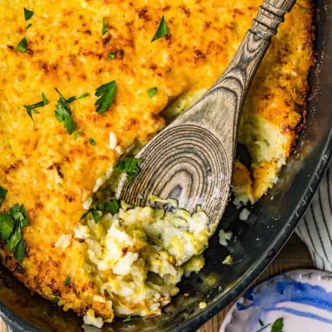 zucchini gratin in pan with wooden spoon