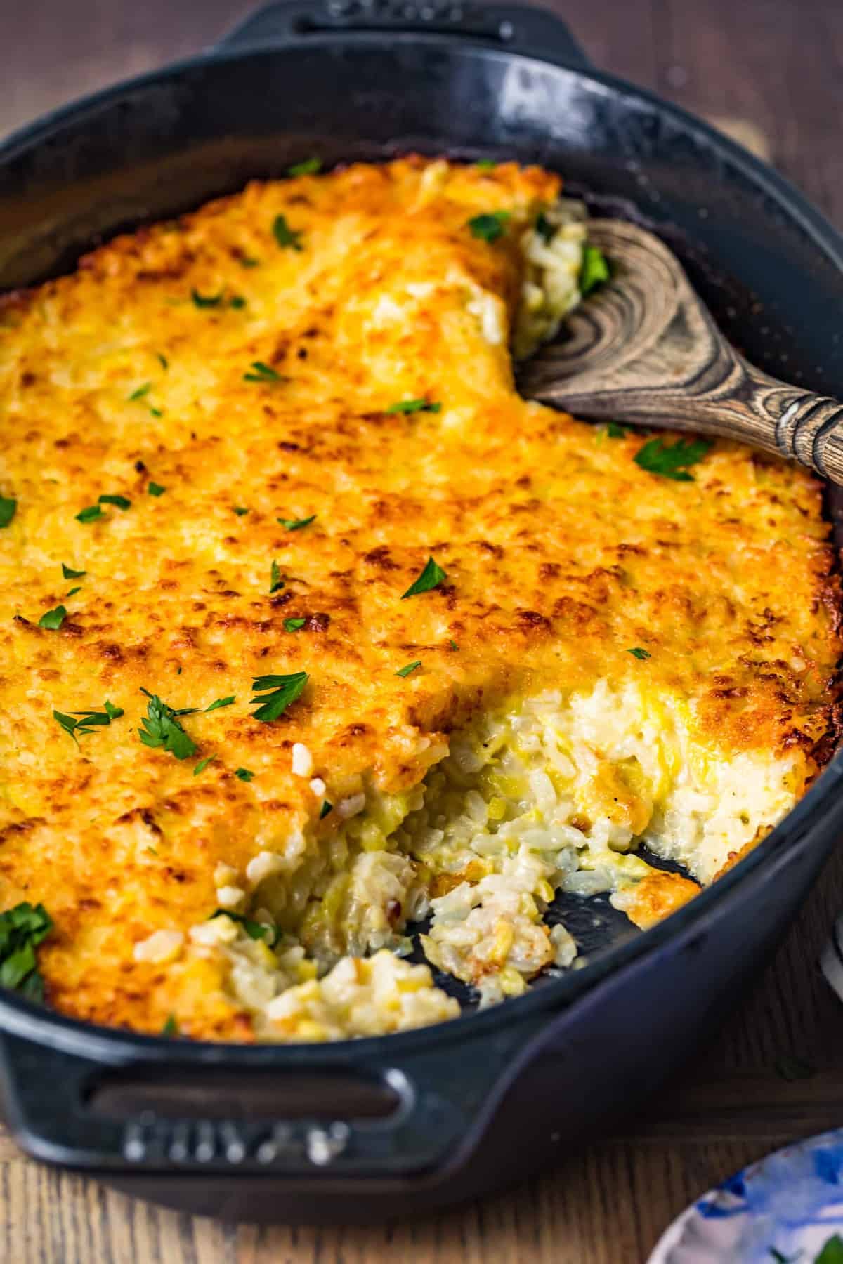 Zucchini gratin in a black baking dish with pieces served out of it