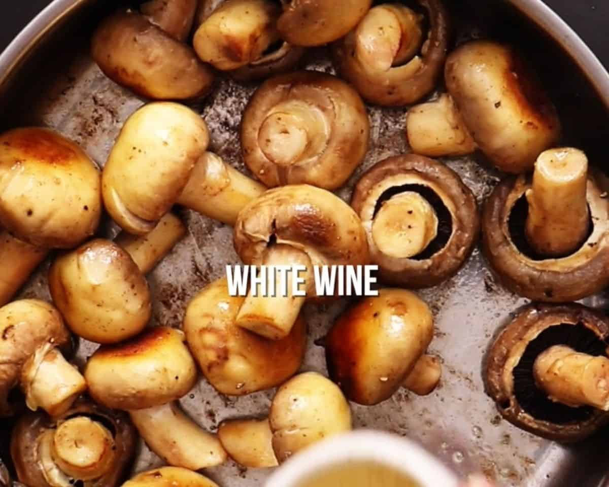 Adding wine to the pan of mushrooms.