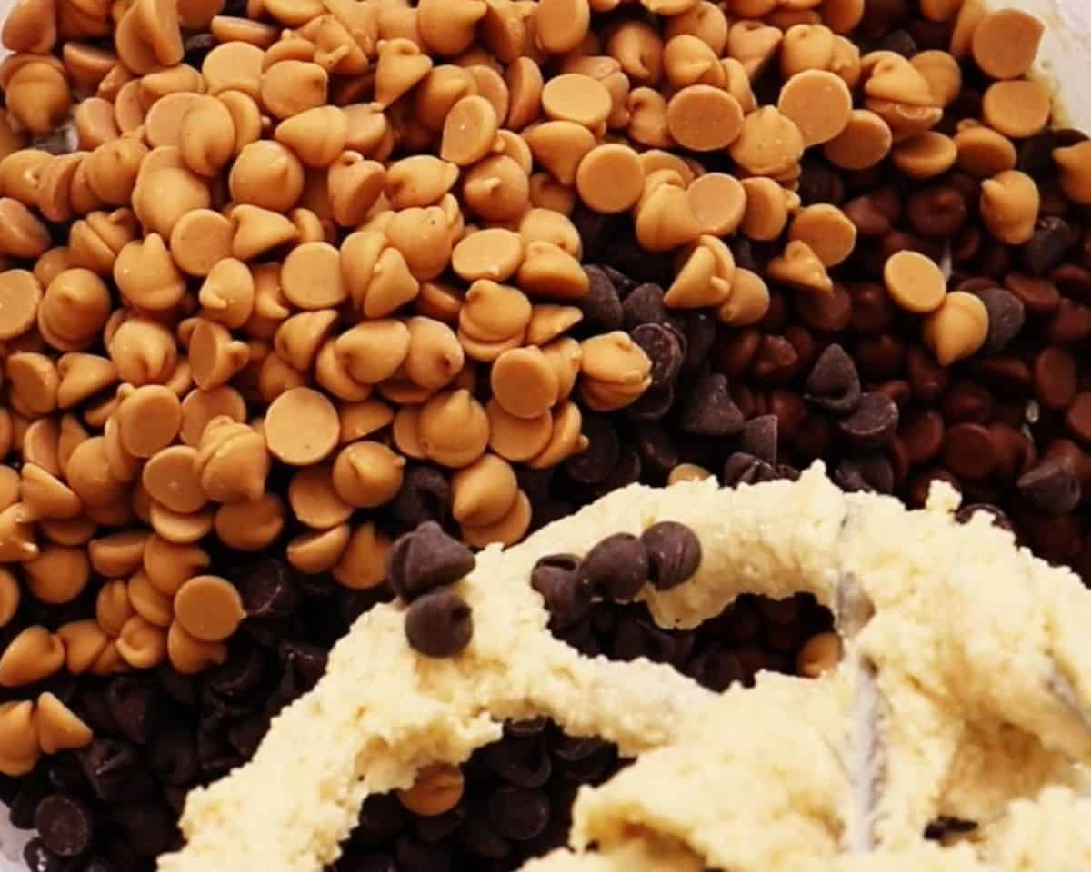 Chocolate chips and peanut butter chips being added to the batter.